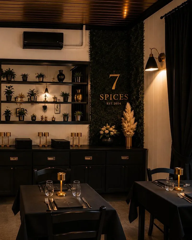 La sala di 7 Spices con i tavoli apparecchiati in nero e oro